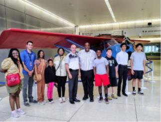 photo of Aviation Station youth and staff in front of plane