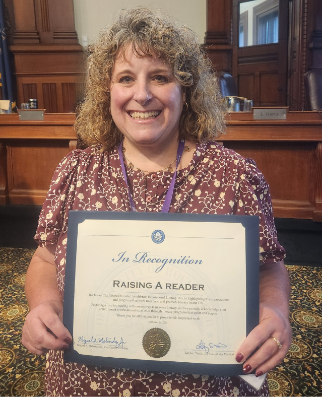 photo of Tonia Burton with Raising a Reader certificate of recognition